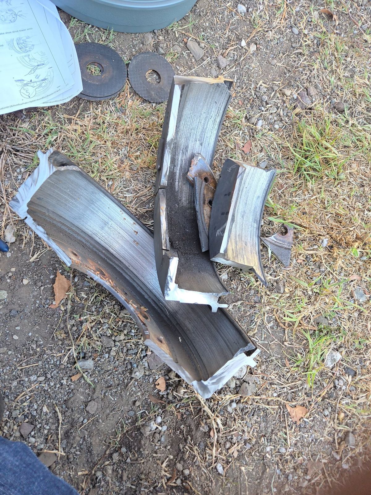 Destroyed brake shoes removed from the 2011 Toyota Tacoma, lying in the dirt