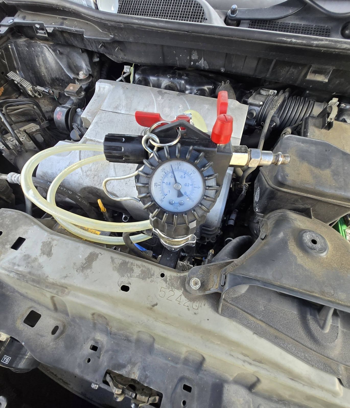 Cooling system pressure tester connected to an engine