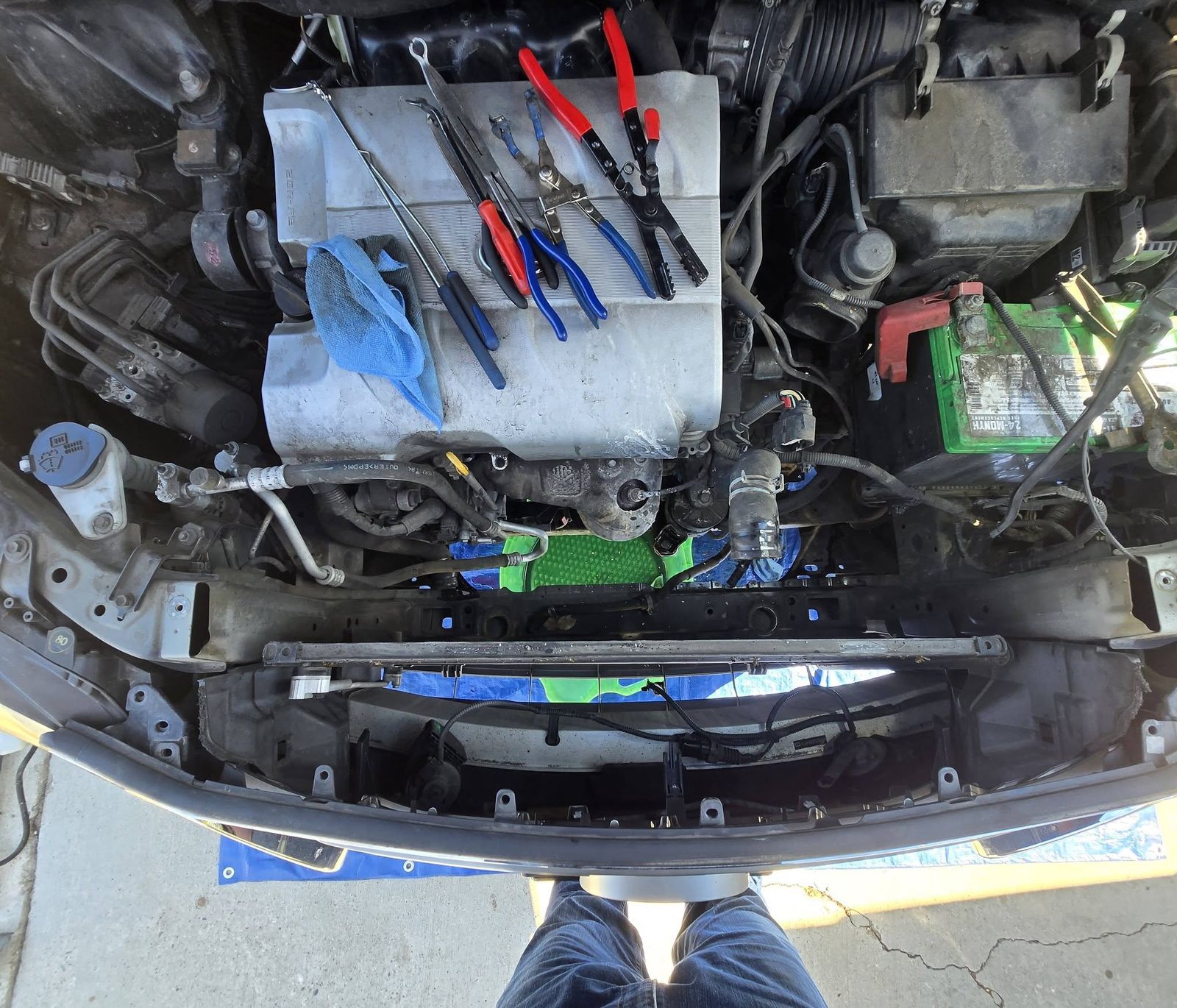 Same vehicle with the radiator out and tools laid across the engine cover