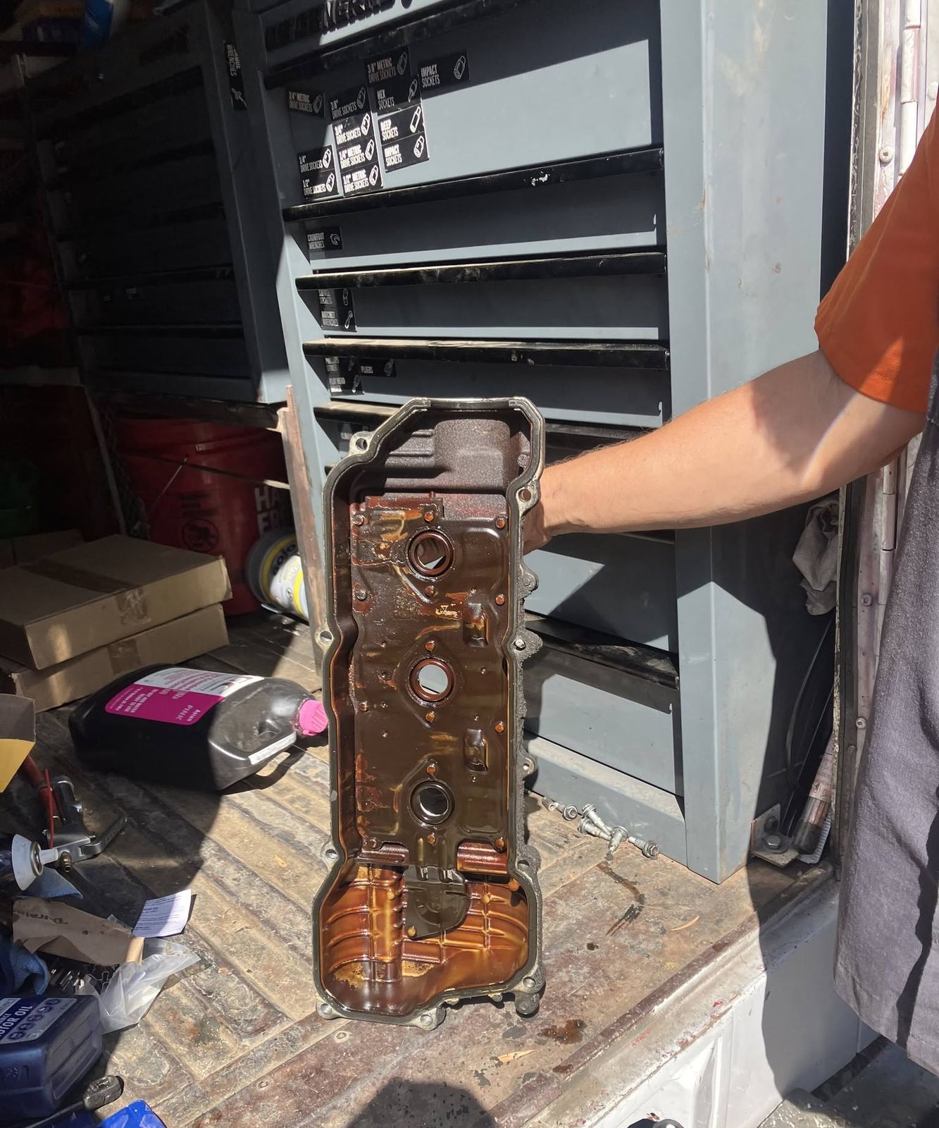 Valve cover with heavy oil residue held up after removal