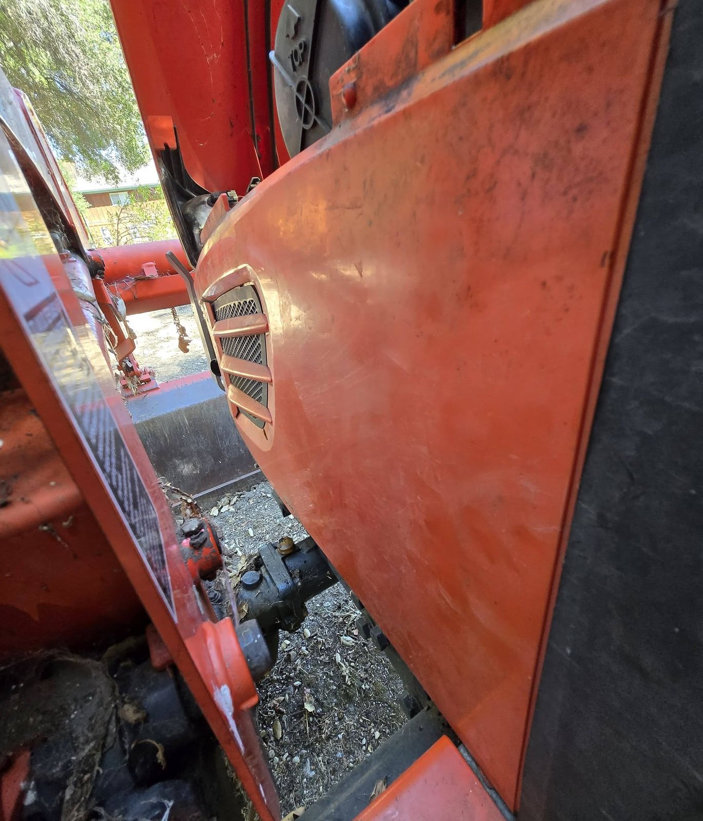 Orange compact tractor with its hood panel opened