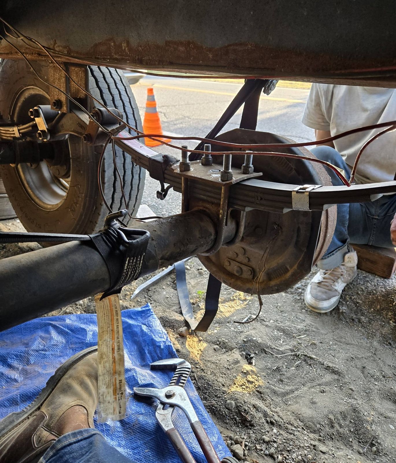 Working under a trailer axle and leaf spring, repaired on-site